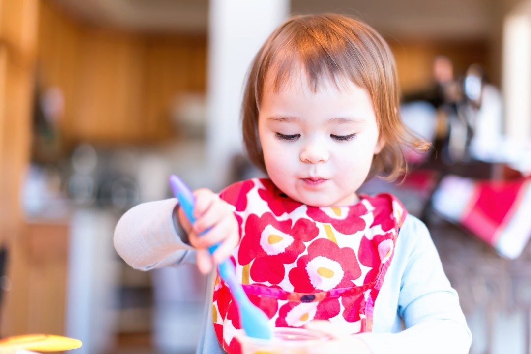 graphicstock-toddler-girl-eating-food-with-her-spoon-in-her-house_HDMK3InN_b